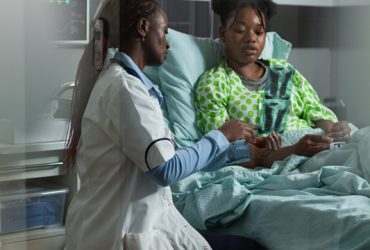 Doctor of african american ethnicity holding radiography